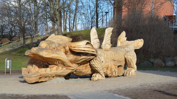 Ein aus Holz geschnitzter, 10 Meter großer Drache liegt vor dem Wasserturm in Grimmen © Stadt Grimmen - Pressestelle 