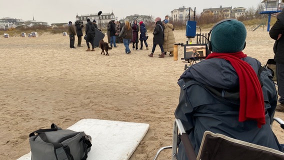 Filmszene am Strand von Ahlbeck - Vordergrund der Rücken der Regisseurin im Hintergrund eine Filmcrew mit Kamera und Ton und vielen Mitwirkenden © NDR Foto: Mirja Freye