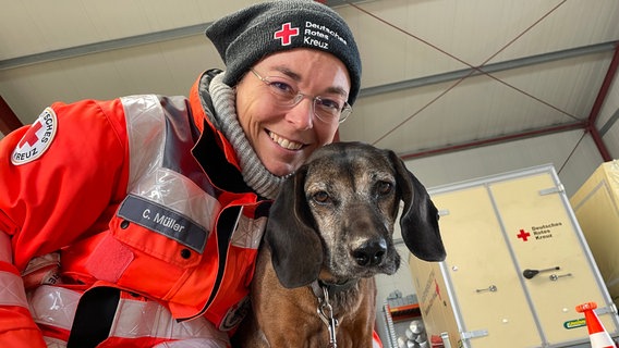 Auf dem Bild ist ein Rettungshund mit seiner Besitzerin zu sehen. © NDR Foto: Paula Deusing