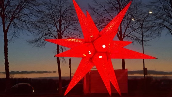 Ein über 7 Meter hoher Stern leuchtet in der Farbe rot. © NDR Foto: Michaele Rüting