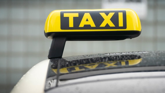 Ein Taxi-Schild ist auf dem Dach eines Fahrzeuges befestigt. © dpa Foto: Frank Rumpenhorst/dpa