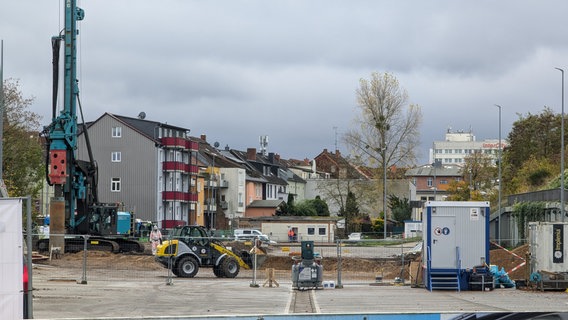 Eine Baustelle mit einem großen Tiefbohrer und einem Radlader. Ein Mensch steht in Schutzkleidung daneben. © Christoph Loose Foto: Chris Loose