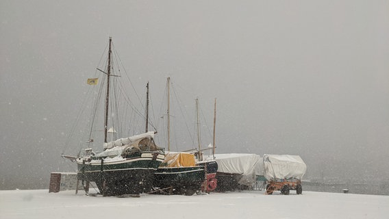 Aufgebockte Boote stehen auf einem verschneiten Strand. © Katja Bülow Foto: Katja Bülow