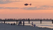 Über der Seebrücke in Zinnowitz ist ein Rettungshubschrauber zu sehen. © Tilo Wallrodt Foto: Tilo Wallrodt