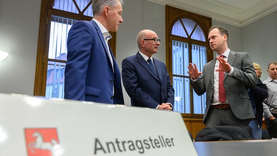 Die Beschwerdeführer Marco Genthe (li) und Alexander Grafe (re) stehen mit ihrem Anwalt (Mitte) im niedersächsischen Staatsgerichtshof. Entschieden wird über die Landtags-Neuwahl. © Julian Stratenschulte/dpa Foto: Julian Stratenschulte/dpa