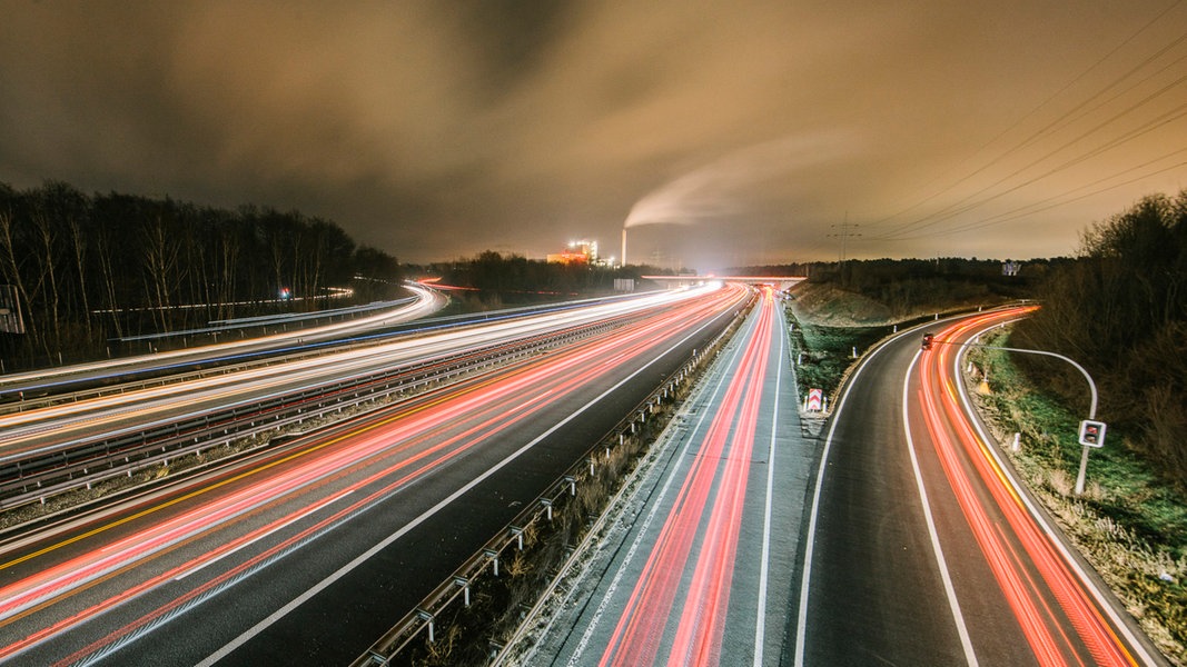 Autos fahren bei Nacht über eine Autobahn. 