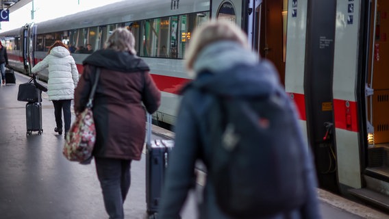 Reisende laufen an einem Gleis des Hauptbahnhof Hannovers an einem ICE mit geöffneten Türen vorbei. © picture alliance/Maximilian Koch Foto: Maximilian Koch