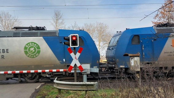 Güterzug fährt an einem geschlossenen Bahnübergang vorbei © NDR Foto: Julia Scheper