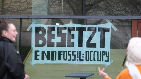 Ein Transparent mit der Aufschrift „Besetzt - End Fossil: Occupy“ hängt an einem Gebäude einer Universität. © picture alliance/dpa | Sebastian Willnow Foto: Sebastian Willnow