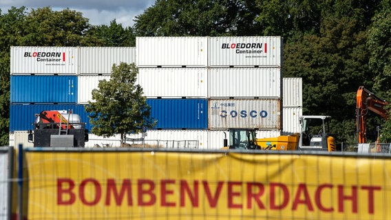 Ein Banner mit der Aufschrift "Bombenverdacht in der Weststadt" ist als Sichtschutz vor Containern am westlichen Schützenplatz in Göttingen befestigt. © picture alliance/dpa | Swen Pförtner Foto: Swen Pförtner