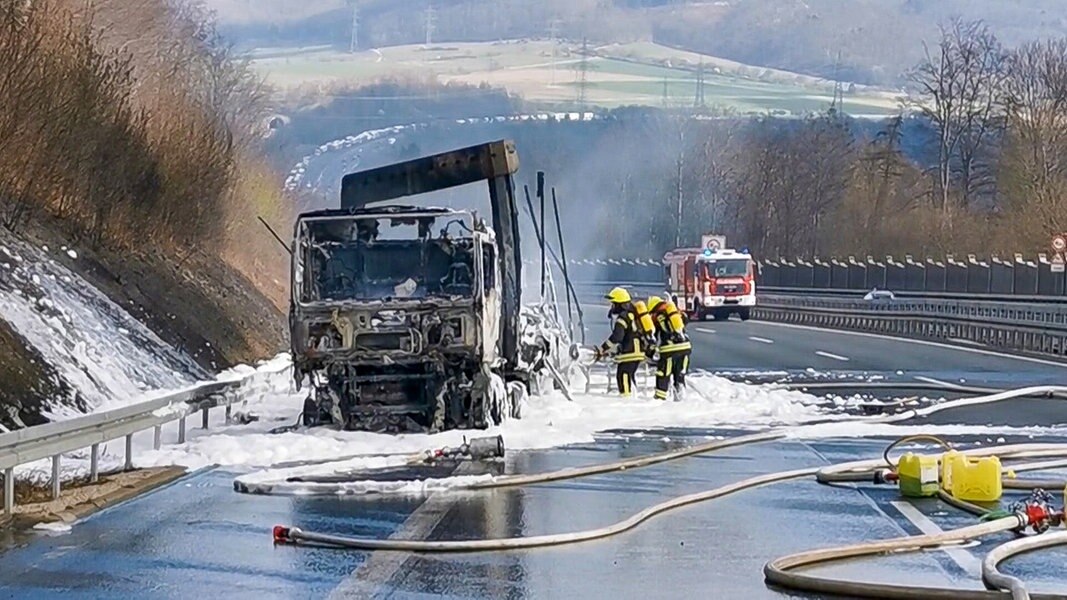 Feuerwehrleute löschen einen brennenden Lkw auf der A7 zwischen Hann. Münden und Kassel