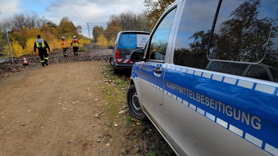 An einem Weg stehen zwei Fahrzeuge der Kampfmittelbeseitigung. © NDR Foto: Kevin Poweska