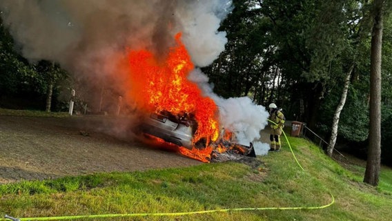 Ein brennendes Auto an der Autobahn 1 wird gelöscht. © Kreisfeuerwehr Oldenburg 