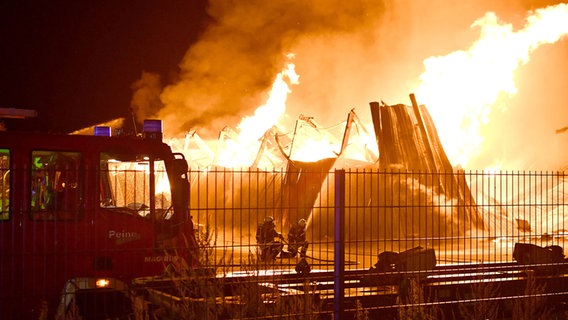 Feuerwehrleute löschen einen Brand in Peine, hohe Flammen schlagen aus einem eingestürzten Gebäude. © Jörg Koglin Foto: Jörg Koglin