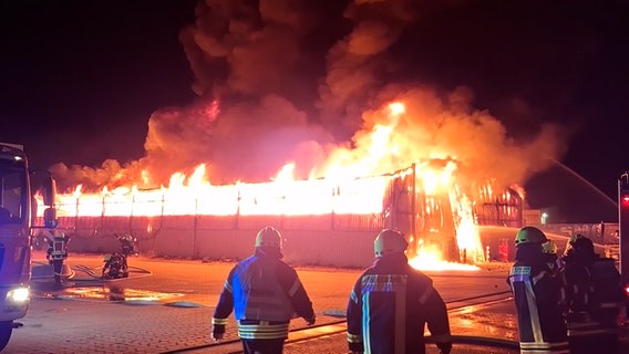 Feuerwehrleute löschen einen Brand in Peine, hohe Flammen schlagen aus einem eingestürzten Gebäude. © HannoverReporter 