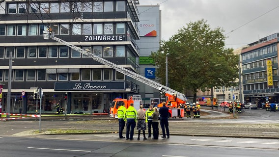 Feuerwehrleute und eine Drehleiter an einem Geschäftshaus in Braunschweig © NDR Foto: Andreas Mier