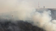 Ein Löschhubschrauber fliegt über einen Waldbrand am Brocken. © Nord-West-Media TV 