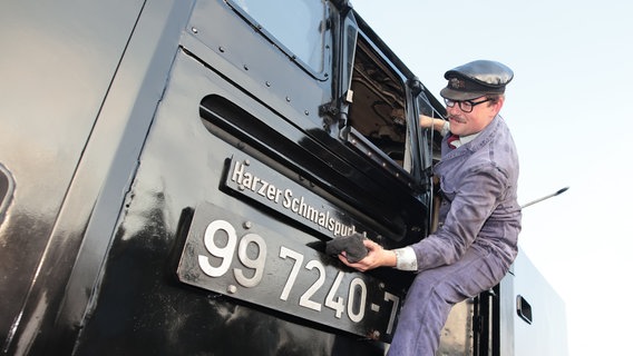 Caleb Lovegrove von der Ffestiniog and Welsh Highland Railways (FR/WHR) aus Wales reinigt mit einem Tuch eine Dampflok an der Einsatzstelle der Harzer Schmalspurbahnen GmbH. © dpa-Bildfunk Foto: Matthias Bein