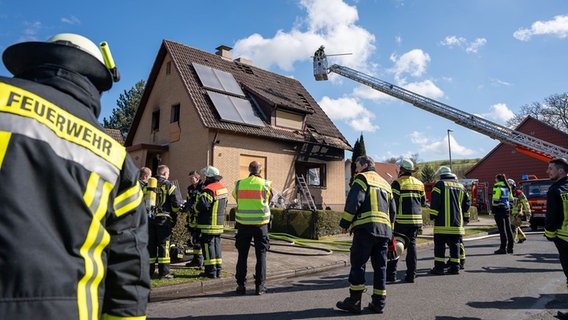 Einsatzkräfte der Feuerwehr stehen nach einer Explosion vor einem Wohnhaus in Dassel. © Kreisfeuerwehr Landkreis Northeim 