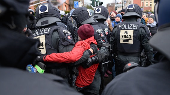 Einsatzkräfte der Polizei tragen bei einer Demonstration des "Göttinger Bündnisses gegen Rechts" gegen Querdenker und extreme Rechte einen Teilnehmer von der Straße. © dpa Foto: Swen Pförtner