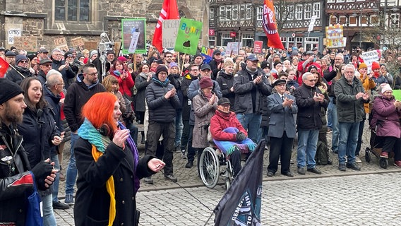 Teilnehmer an einer Demonstration gegen Rechtsextremismus in Hann. Münden stehen zusammen und klatschen in die Hände. Viele tragen Fahnen. © NDR Foto: Bärbel Wiethoff