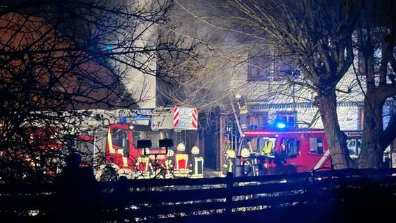 Mehrere Feuerwehrleute stehen vor einem brennenden Haus in Düna (Osterode im Harz). © Stadt Osterode Foto: Stadt Osterode