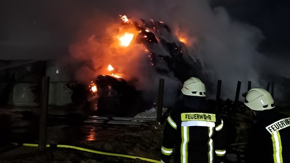 Einsatzkräfte der Feuerwehr löschen brennende Strohballen. © Feuerwehr Einbeck 