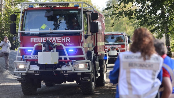 Einsatzkräfte der Feuerwehr und weiterer Rettungskräfte stehen im Rahmen einer Großübung zur Waldbrandbekämpfung im Harz. © picture-alliance Foto: Matthias Bein