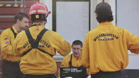 Einsatzkräfte tragen Kleidung mit der Aufschrift "Waldbrandteam - Fire Crew". © dpa-Bildfunk Foto: Matthias Bein