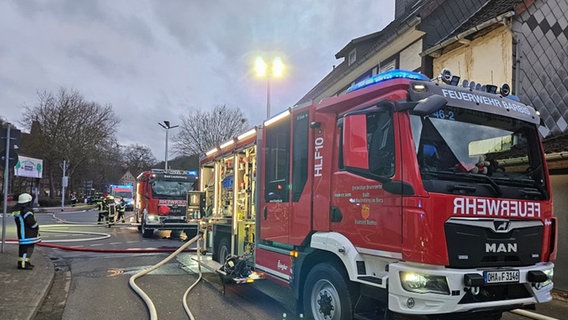 Zwei Feuerwehrautos, an denen Schläuche befestigt sind, stehen während eines Einsatzes an einer Straßenabbiegung. © Freiwillige Feuerwehr Barbis 