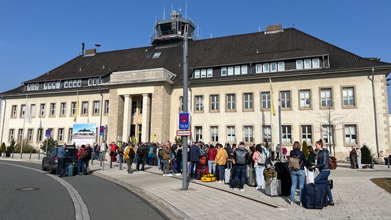 Fluggäste stehen in einer langen Schlange vor dem Flughafen in Braunscheig. © NDR Foto: Matthias Zimmermann