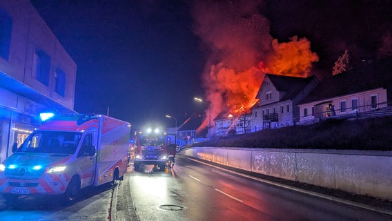 Feuerwehrleute löschen einen brennenden Dachstuhl während es dunkel ist. © FW Bad Lauterberg Foto: FW Bad Lauterberg