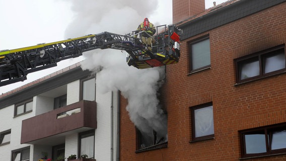 Einsatzkräfte der Feuerwehr befreien mit einer Drehleiter Menschen aus einer brennenden Wohnung. © Stefan Rampfel Foto: Stefan Rampfel