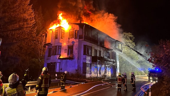 Feuerwehrleute löschen ein brennendes Gebäude im Oktertal, aus dessen Dach Flammen schlagen. © Feuerwehr Goslar 