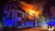 Feuerwehrleute löschen ein brennendes Gebäude im Oktertal, aus dem Flammen schlagen. © Feuerwehr Goslar 