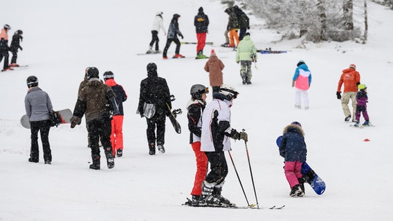 Wintersportler sind auf einen Hang im Harz unterwegs. © dpa Foto: Swen Pförtner