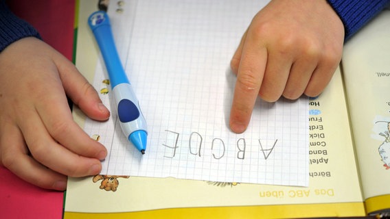 Ein Grundschulkind mit einem Lehrbuch. © dpa-Bildfunk Foto: Frank May