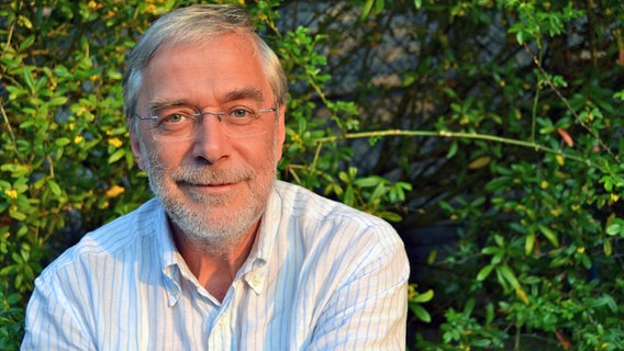 Der Vorsitzende der Akademie für Potentialentfaltung Gerald Hüther ist auf einem Porträtfoto vor einer Hecke zu sehen. © www.gerald-huether.de 