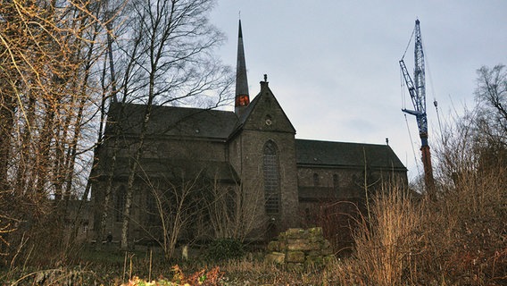 Ein Kran steht neben der Klosterkirche Amelungsborn.  