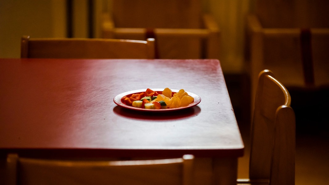 Auf einem Tisch in einer Kindertagesstätte steht ein Teller mit Rohkost.