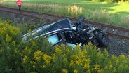 Ein Pkw liegt nach einer Kollision mit einem Personenzug auf einem Gleis. © HannoverReporter 