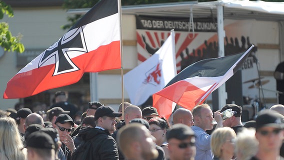 Die rechten Demonstranten schwenken ihre Fahnen auf dem Hagenmarkt in Peine. © dpa-Bildfunk Foto: Dominique Leppin