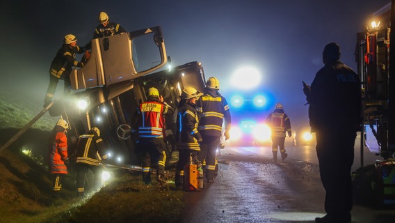 Feuerwehrleute an einem umgekippten Lkw auf der A7 bei Northeim © Kreisfeuerwehr Northeim Foto: Konstantin Mennecke