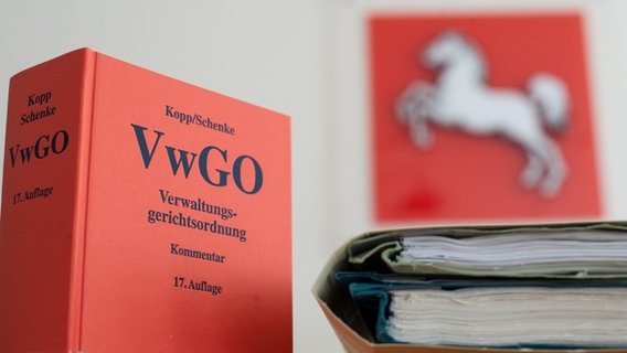 Die Verwaltungsgerichtsordnung steht neben Akten im Niedersächsischen Oberverwaltungsgericht (OVG) auf einem Tisch. © dpa-Bildfunk Foto: Philipp Schulze