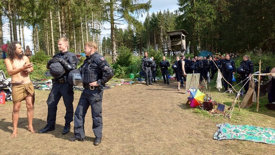 Polizeibeamte sprechen mit Teilnehmen des "Rainbow Gathering" im Harz. © NDR Foto: Marco Schulze