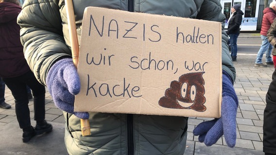 In Braunschweig hält eine Person ein Pappschild mit der Aufschrift "Nazis hatten wir schon, war kacke". © NDR Foto: Ute Andres