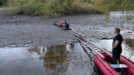 Rettungskräfte bergen eine Person aus dem Schlamm eines Flusses. © Feuerwehr Holzminden 