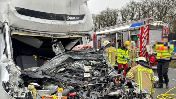 Mehrere Feuerwehrleute arbeiten, während im Vordergrund ein schwer beschädigter Transporter zu sehen ist. © Feuerwehr Helmstedt Foto: Feuerwehr Helmstedt