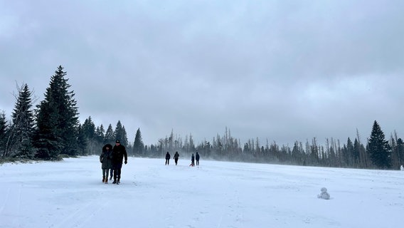 Menschen gehen im verschneiten Harz spazieren. © NDR Foto: Marie Schiller