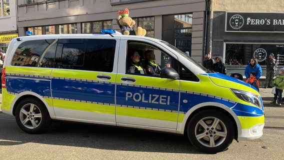 Auf einem Polizeiwagen sitzt ein Teddy mit Karnevalsmütze und Polizeiuniform beim Schoduvel in Braunschweig 2025. © NDR Foto: Ute Andres